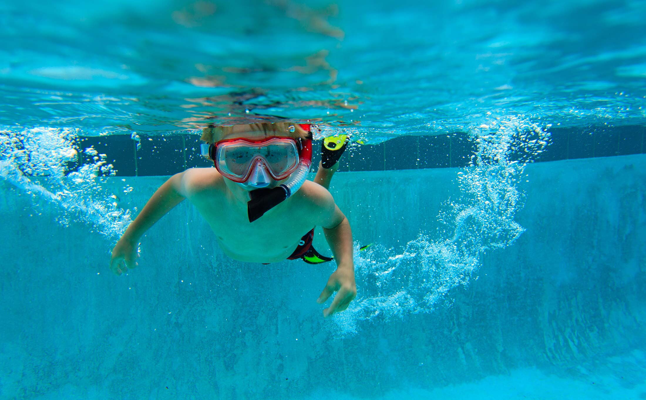 Kind zwemt onder water met snorkel